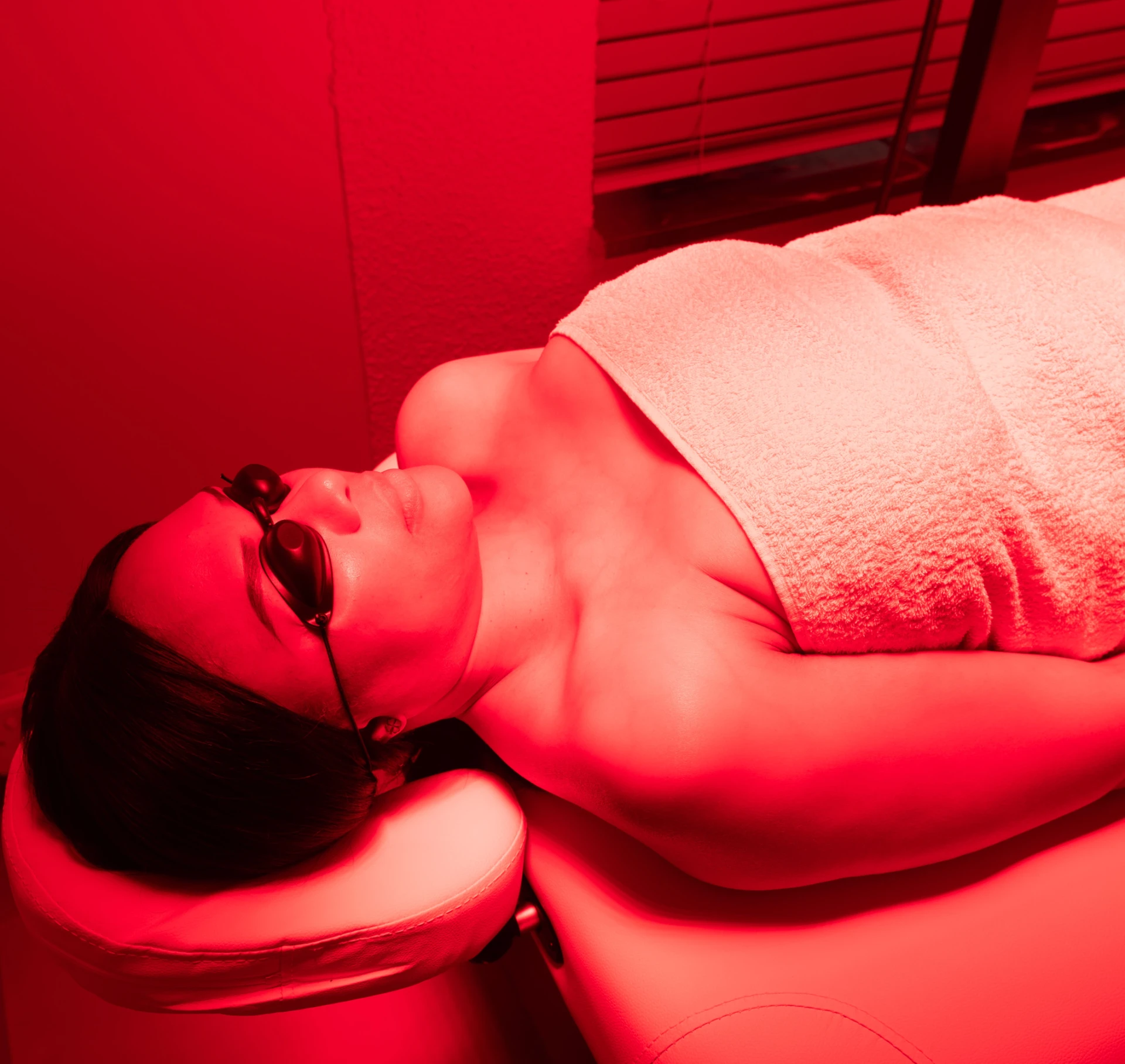 Client relaxing during a full-body red light near-infrared session at Rohalya Wellness